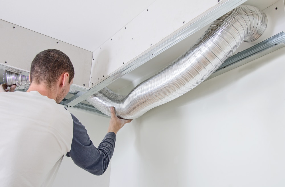 man adjusting ventilation tubing at home