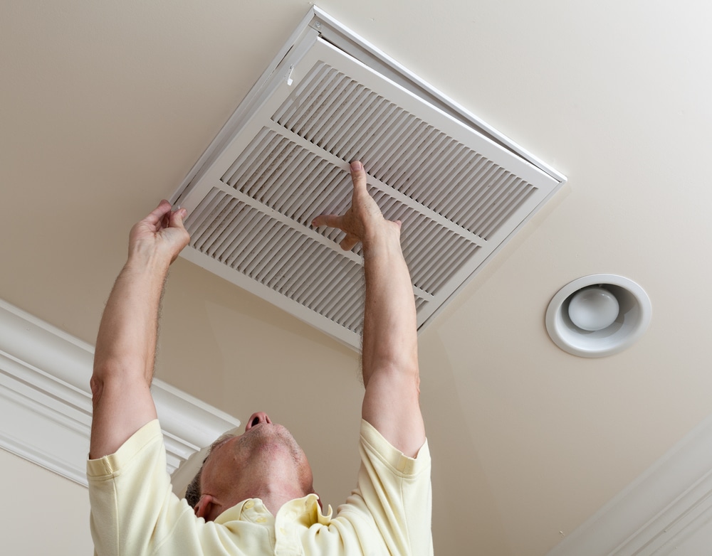 man opening ceiling vent